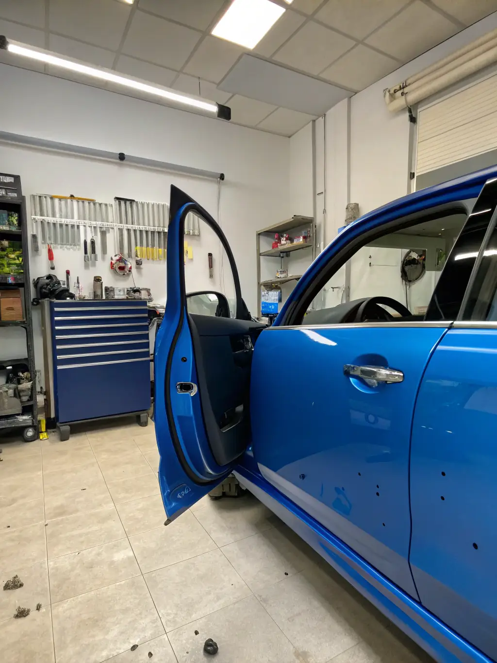 Close-up shot of a car door with PPF applied, resisting scratches from keys, demonstrating scratch resistance.